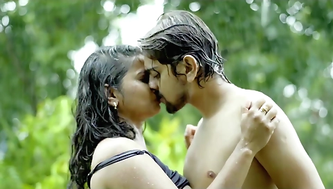 Brunette teen in a white dress and shorts is standing on the grass