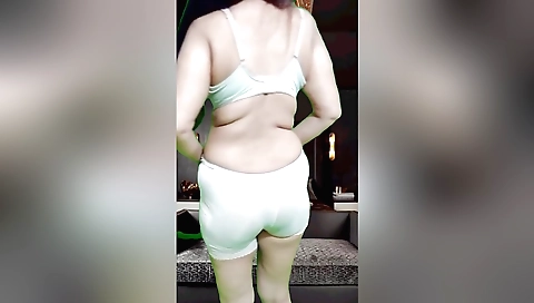 Busty brunette shows off her curves in front of camera